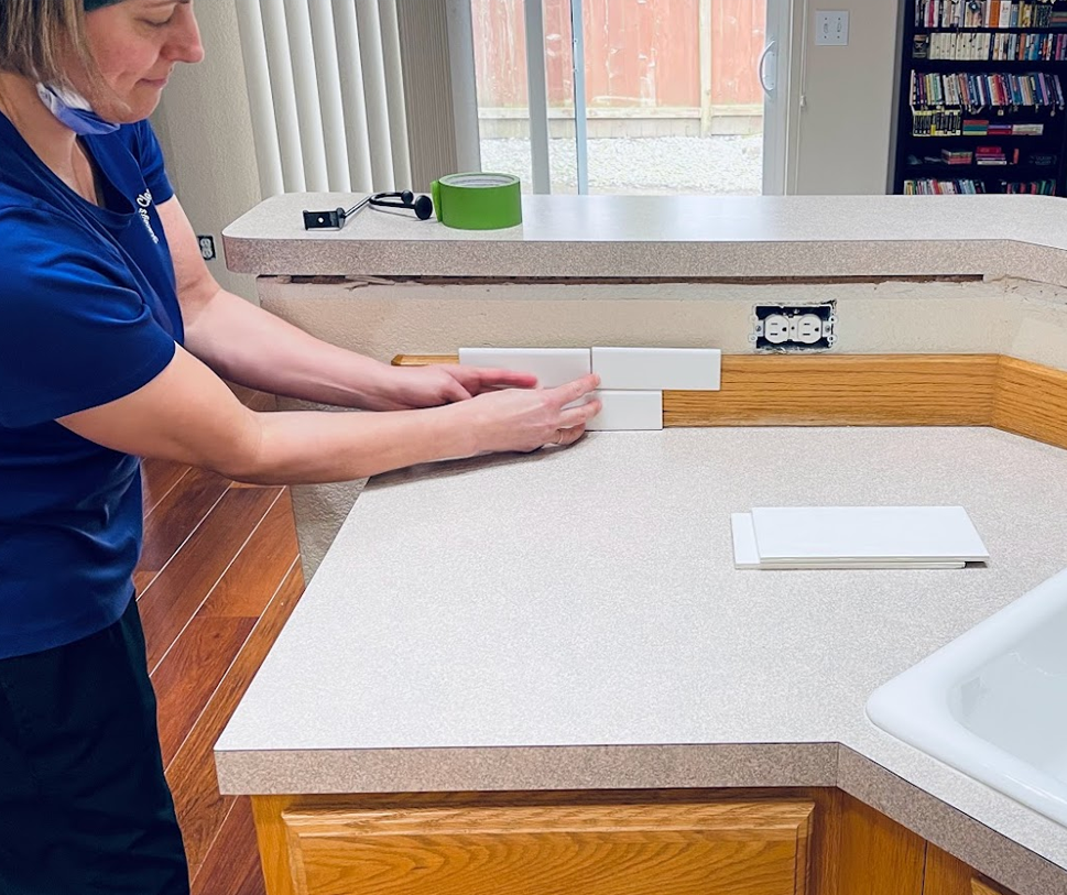 Woman tiling kitchen counter